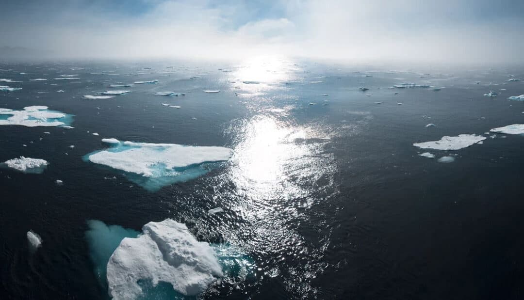 Greenland Icecaps Melting in the Ocean with the Sun rising on the Horizon