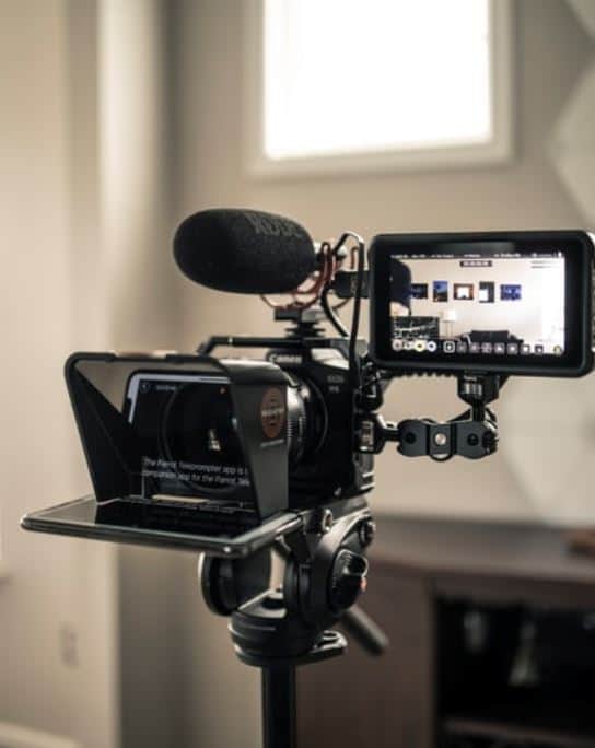 Black video camera on a tripod showing off interior design on the screen