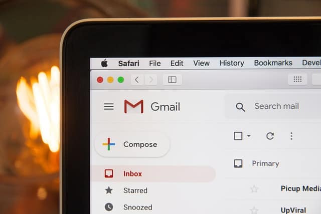 Image of Gmail inbox in the upper left corner of a laptop.
